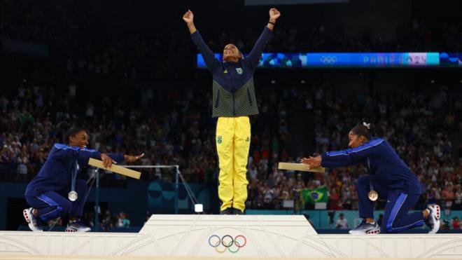 Simone Biles en el podio junto a Rebeca Andrade y Jordan Chiles (Fuente: @Olympics)