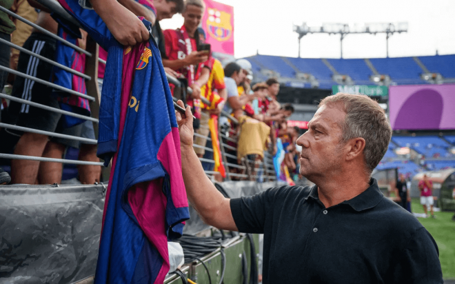 Hansi Flick firmando una camiseta del Barça (Foto: FCB).