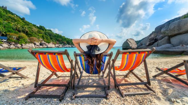 Mujer en la playa sentada en una hamaca (Fuente: Freepik)