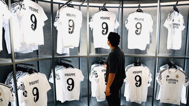 Un aficionado observa las camisetas de Mbappé del Real Madrid (Cordon Press)