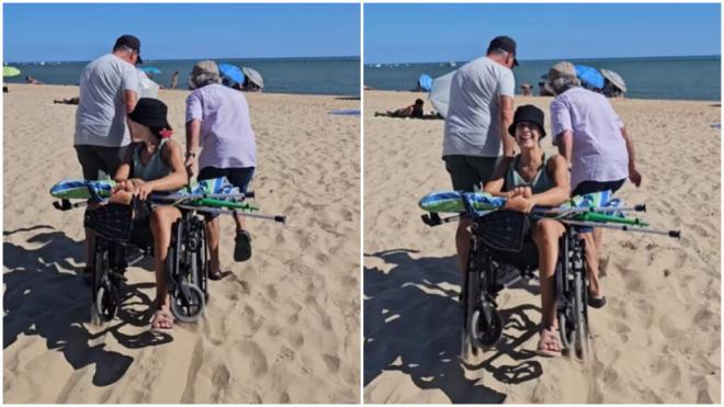 Carolina Marín entra a la playa con la ayuda de dos voluntarios.