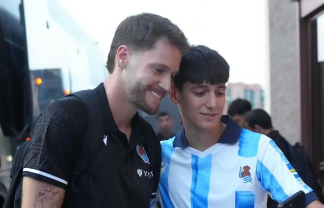 Álex Remiro se fotografía con un aficionado a la llegada a Madrid (Foto: Real Sociedad).