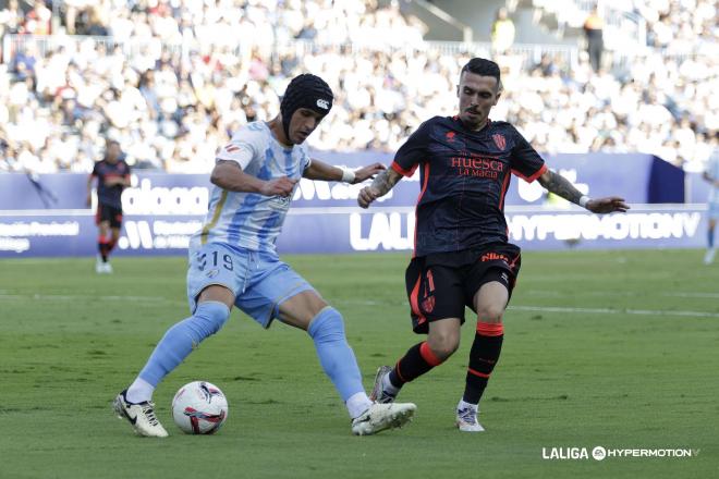 Luismi Sánchez protege el balón en el Málaga - Huesca (Foto: LALIGA).