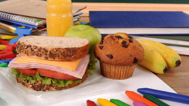 Merienda compuesta de sándwich mixto, magdalena, manzana y zumo (Foto: Freepik)