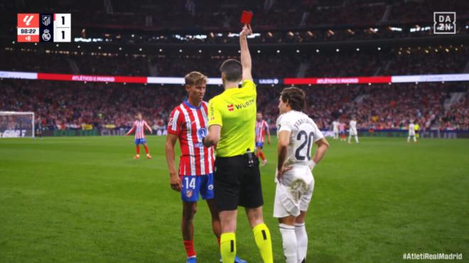 Marcos Llorente, recibiendo la cartulina roja en el derbi tras revisar la acción el VAR (foto: cap