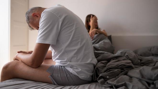 Pareja de hombre y mujer en la cama con signos de estar preocupados por algo (Foto: Freepik)