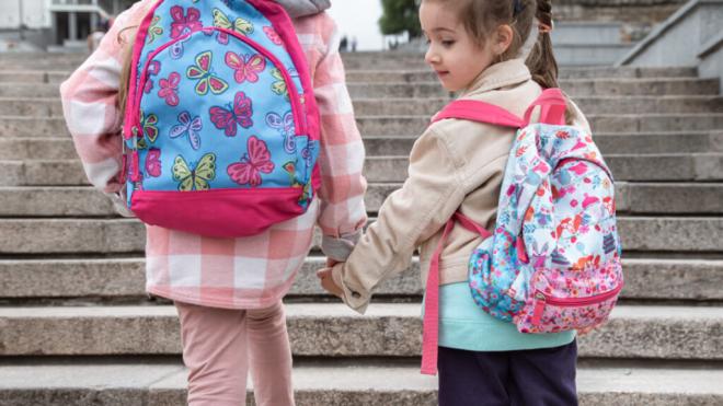 Dos niñas subiendo unas escaleras con mochilas colgadas a sus espaldas (Foto: Freepik)