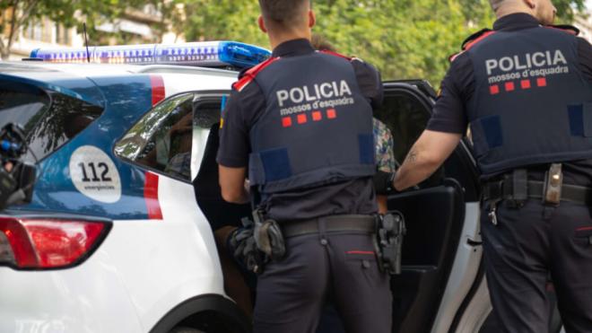 Imagen de archivo de agentes de Mossos d'Esquadra junto a un coche oficial (Europa Press)