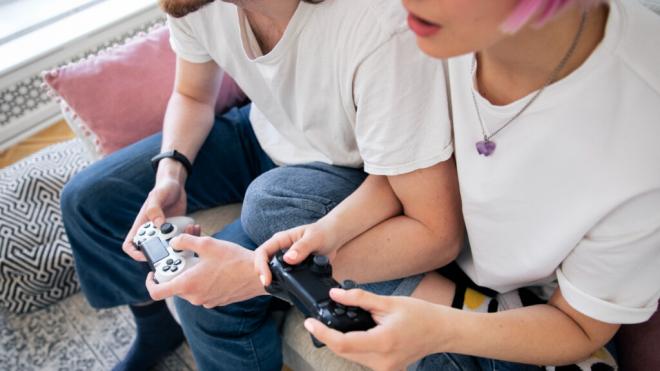 Pareja jugando a videojuegos en el sofá (Foto: Freepik)