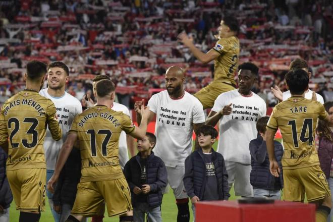 Los jugadores del Sevilla, con una camiseta en apoyo a Valencia (Foto: Kiko Hurtado).