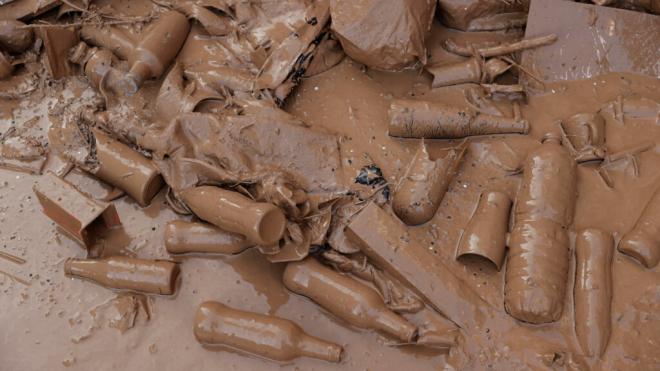 Varios botellas cubiertas de barro en Paiporta, Valencia, tras la DANA (Foto: EFE)