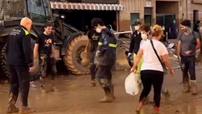 Voluntarios y policías juegan en Paiporta mientras esperaban que les trajeran una bomba para extra