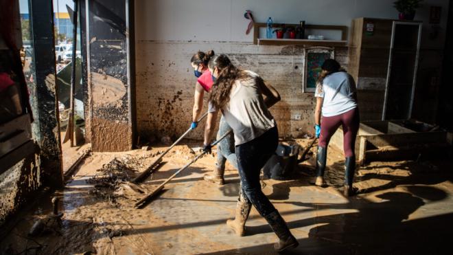 Grupo de chicas limpiando un bajo afectado por la DANA en Valencia (Foto: Cordon Pres)