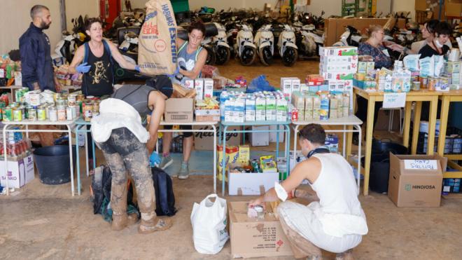 Voluntarios reparten bienes de primera necesidad entre los vecinos de Masanasa, Valencia (Foto: EFE)