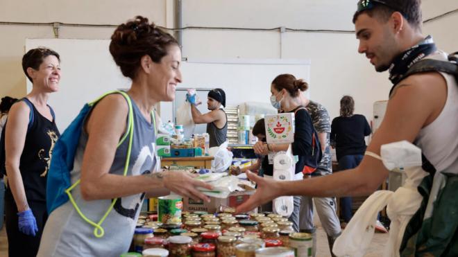 Voluntarios reparten bienes de primera necesidad entre los vecinos de Masanasa, Valencia (Foto: EFE)