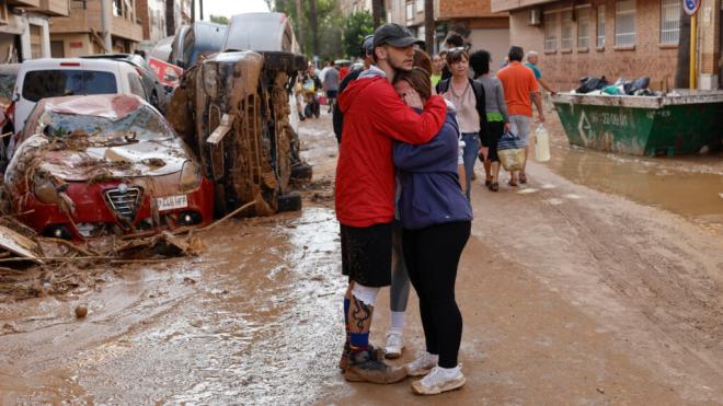 Dos personas abrazadas en una zona afectada por la DANA (Foto: EFE)