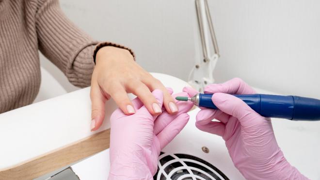 Mujer realizándose la manicura con un torno eléctrico (Foto: Freepik)