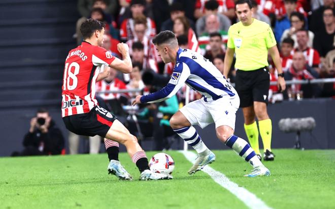 Barrene intenta progresar con el balón ante la presión de Óscar de Marcos (Foto: Real Sociedad).