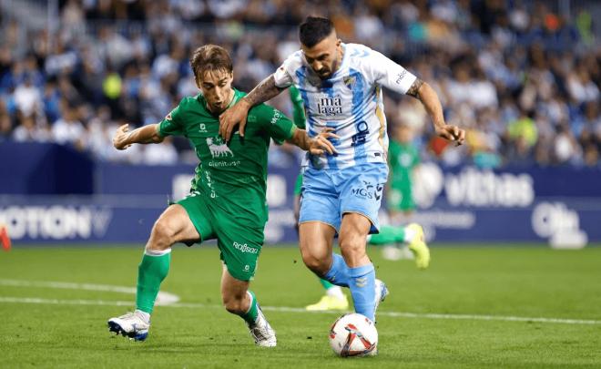 Dioni trata de finalizar a gol en el Málaga - Racing. (Foto: MCF)