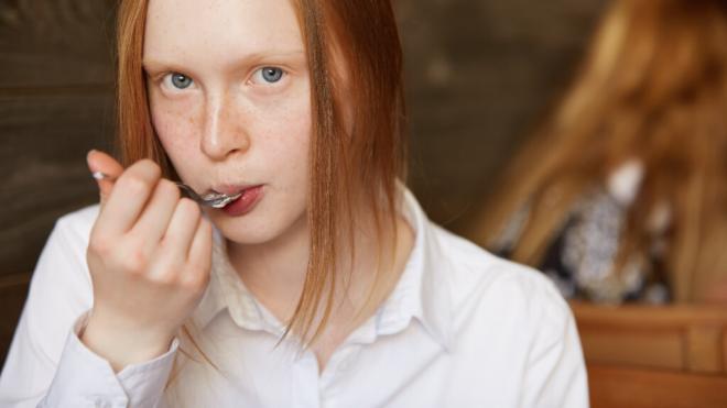 Adolescente comiendo algo de una cuchara (Foto: Freepik)