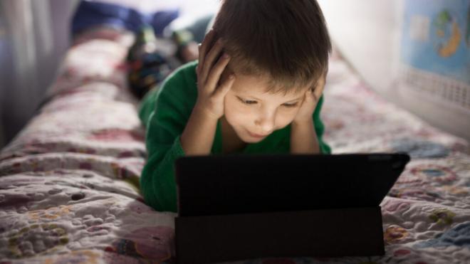 Niño tumbado en la cama con la Tablet (Foto: Freepik)