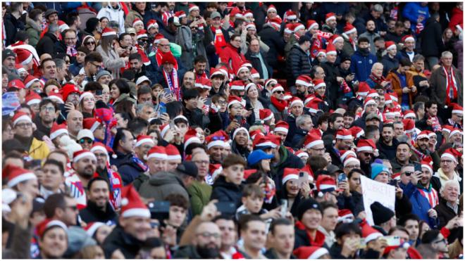 Los aficionados del Atlético de Madrid con gorros de Papá Noel en el Metropolitano (Fuente: EFE)