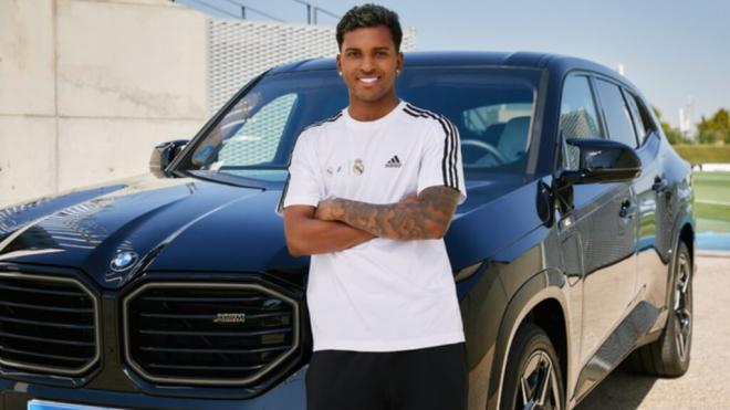 Rodrygo Goes posa junto a uno de los coches en venta (BMW)