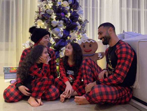 Salah posa junto a su familia bajo el árbol de Navidad.