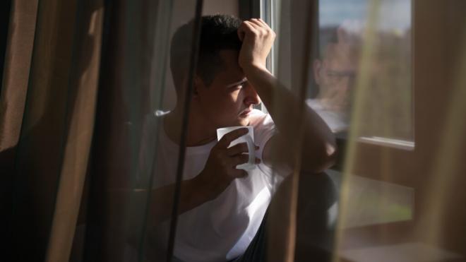 Hombre mirando por la ventana (Foto: Freepik)