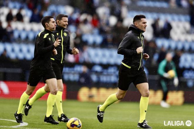 Miguel Ángel Ortiz Arias calienta en Balaídos junto a sus jueces de línea (Foto: LALIGA).