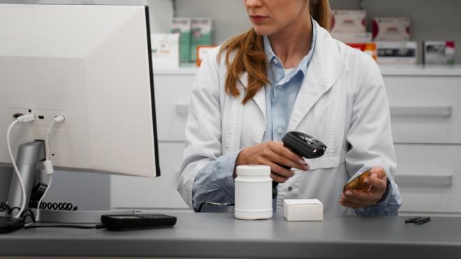 Farmacéutica pasando el código de barras de un medicamento (Foto: Freepik)