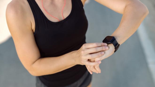 Mujer haciendo deporte y mirando su reloj inteligente (Foto: Freepik)