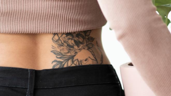 Mujer con un tatuaje lumbar (Foto: Freepik)