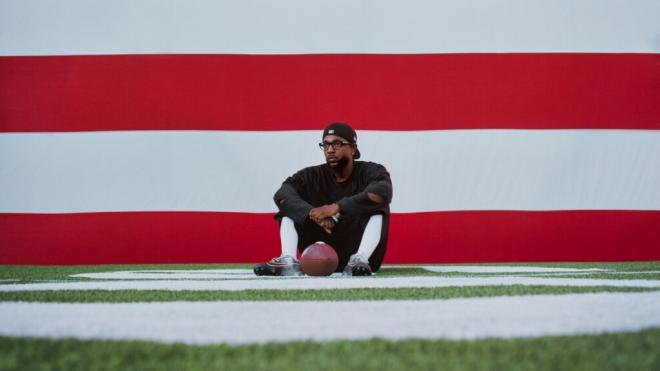 Kendrick Lamar sentado junto a una pelota de fútbol americano (Europa Press)