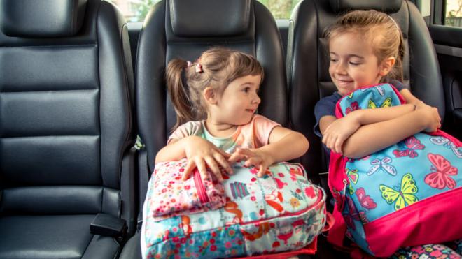 Dos niñas sentadas en la parte de atrás de un coche (Foto: Freepik)