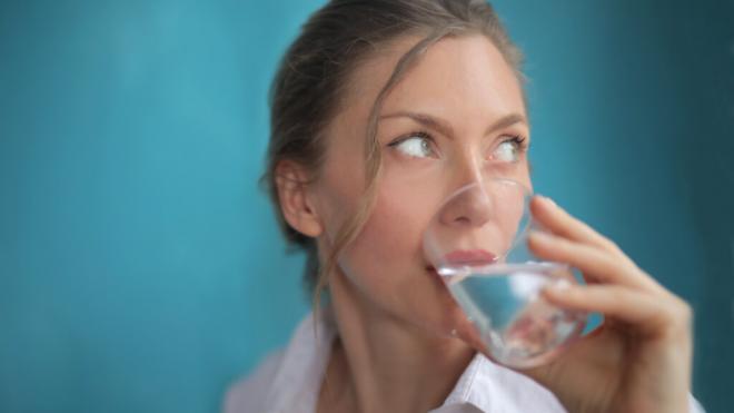 Mujer bebiendo un vaso de agua (Foto: Freepik)