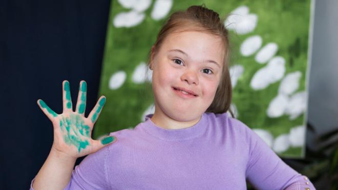 Niña con síndrome de Down pintando con las manos (Foto: Freepik)