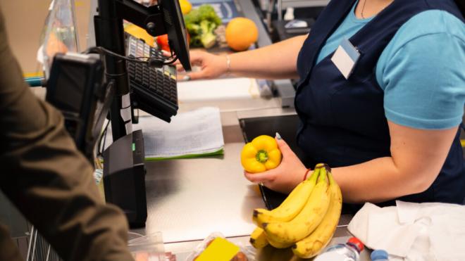 Dependienta de un supermercado cobrando alimentos (Foto: Freepik)