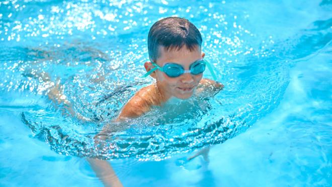 Menor con gafas de bucear nadando en una piscina (Foto: Freepik)