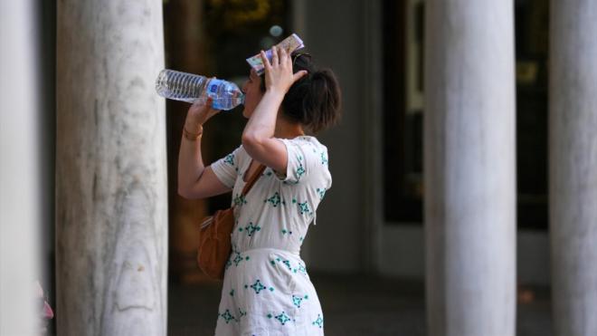 Mujer bebiendo agua para para hacer frente al calor en Sevilla (Foto: Europa Press)