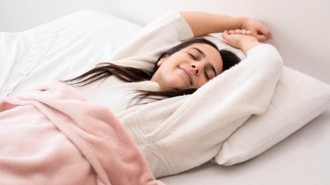 Mujer durmiendo boca arriba (Foto: Freepik)