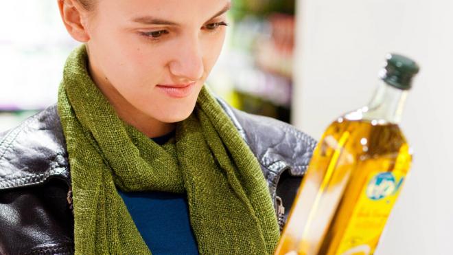 Mujer leyendo los ingredientes de un aceite (Foto: Cordon Press)