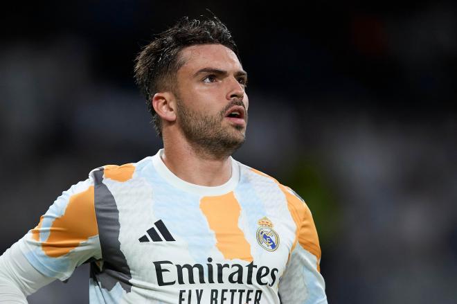Raúl Asencio calienta con el Real Madrid (Foto: CordonPress).