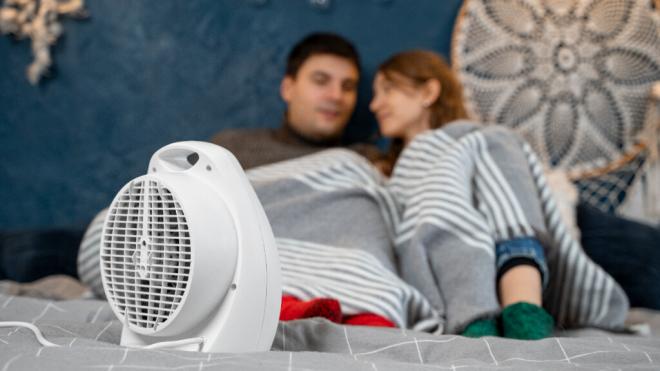 Una pareja arropada con una manta y con un calefactor (Foto: Freepik)