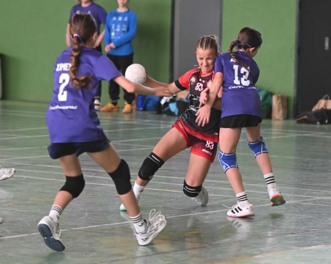 Imagen de un partido de balonmano femenino en edad escolar.