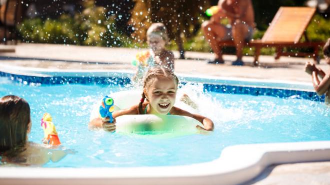 Menores jugando con pistolas de agua en una piscina (Foto: Freepik)