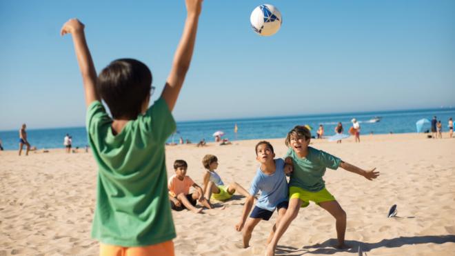 Niños jugando con el balón en la playa (Foto: Freepik)
