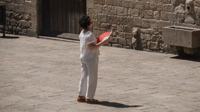 Mujer abanicándose mientras observa un monumento de Barcelona (Foto: Cordon Press)