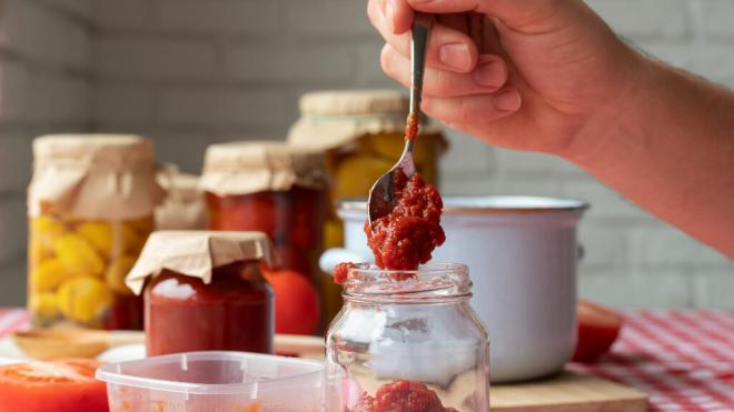 Persona elaborando una conserva de tomate triturado (Foto: Freepik)