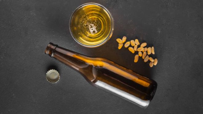 Botellín, vaso de cerveza y frutos secos (Foto: Freepik)